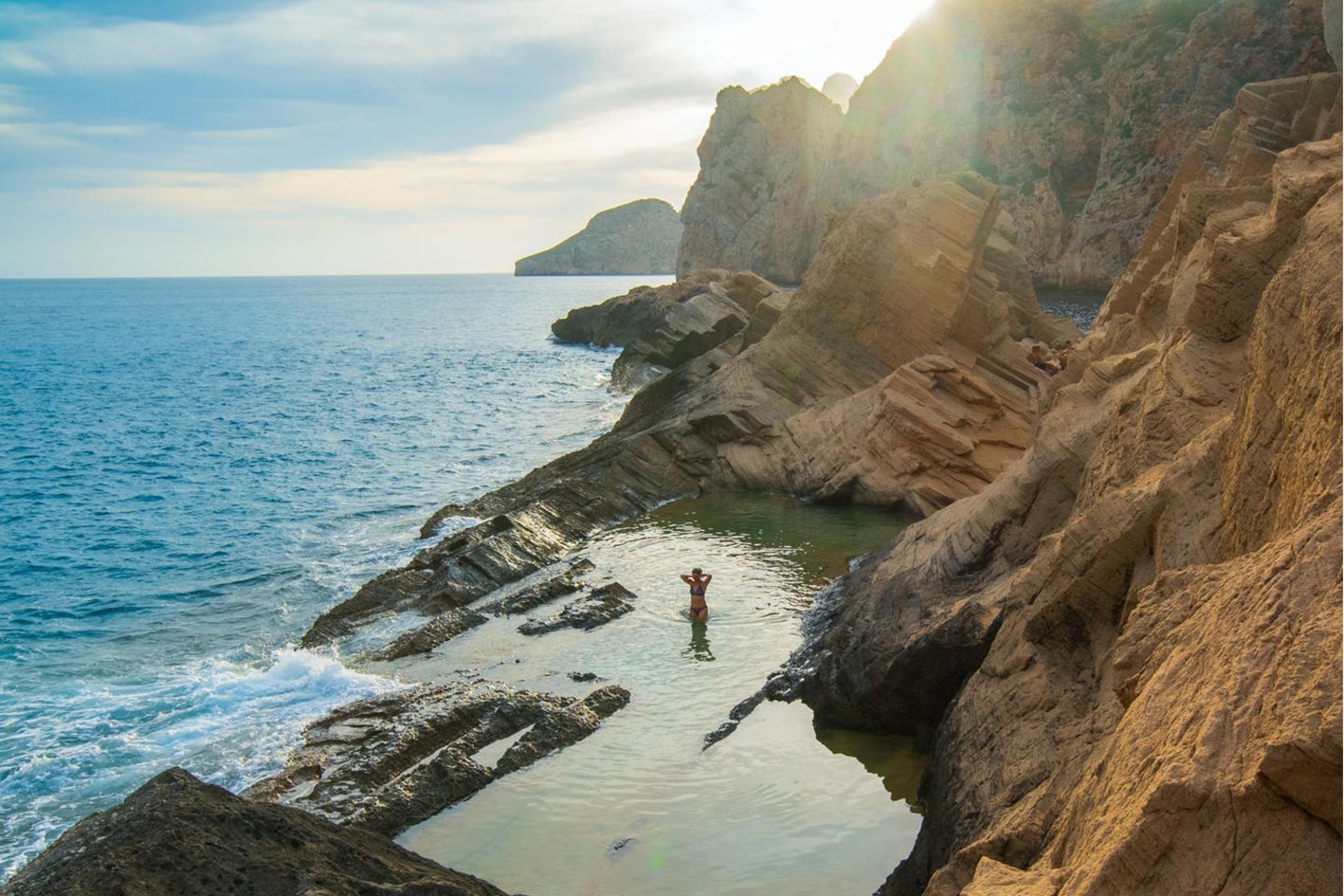Ibiza & Formentera - Sa Pedrera (Atlantis) Alter Sandsteinbruch und mythische Bucht. Mit den hier abgebauten Steinen sollen die Mauern des Weltkulturerbes Dalt Vila in Ibiza Stadt erbaut worden sein. Stellen Sie sich auf eine schweißtreibende 35-minütige Wanderung ohne Wegweiser über Felsen, Baumwurzeln und Sanddünen ein, nehmen Sie genug Trinkwasser mit, und tragen Sie feste Schuhe. Die Mühe lohnt sich, vor allem wenn man am späten Nachmittag kommt, um sich den hinreißenden, flammenden Sonnenuntergang über Es Vedrà anzusehen.  Wegbeschreibung: Von Sant Josep de sa Talaia auf der PMV-803-1 für 7,3 km Richtung Süd- westen, rosa Wegweiser zum Torre des Savinar links. Nach 450 m auf der unbe- festigten Straße irgendwo parken. Dem ausgeschilderten Weg nach Sa Pedrera de Atlantis bis zum Klippenrand folgen. Von hier führen mehrere Wege nach unten.  Erreichbarkeit: Schwer 35 Min