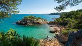 Die Adlerinsel ist ein von Bäumen gesäumter Felsen, der über eine der schönsten Buchten der Costa Dorada wacht. Wenn man auf dem GR92 weitergeht, gelangt man zur Platja de l’Àliga.  Wegbeschreibung: Von Perelló Mar über die Eisen-/Aut bahnbrücke und 4,1 km Richtung Nord- westen, bei der Kreuzung rechts und nach 800 m rechts auf den Camí Corriol de la Punta dels Pins, über die Bahntrasse und nach 170 m links parken. Rechts vom Haus führt ein Weg auf den GR92 (rot- weiße Markierungen auf Felsen und Bäumen). Auf dem GR92 bleiben und nach 500 m die Furche hinunter zum Strand klettern.  Erreichbarkeit: Mittel 15 Min. 