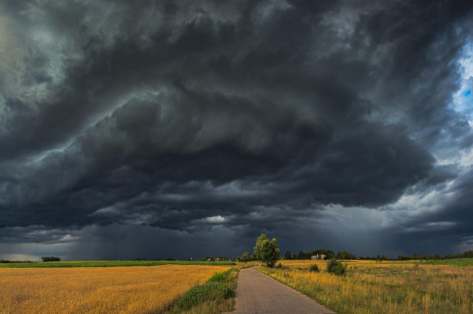 Jahreszeiten verändern sich Dunkler Himmel eines Unwetters über Feldern