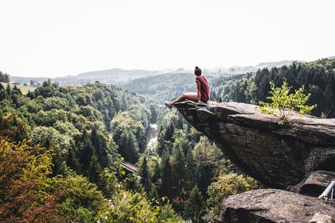 Deutschland, Sachsen, Wolkensteiner Schweiz, Frau sitzt auf einem Felsen, Naturpark ERzgebirge