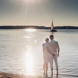 Couple standing at Lake Cospuden in the evening, Sachsen