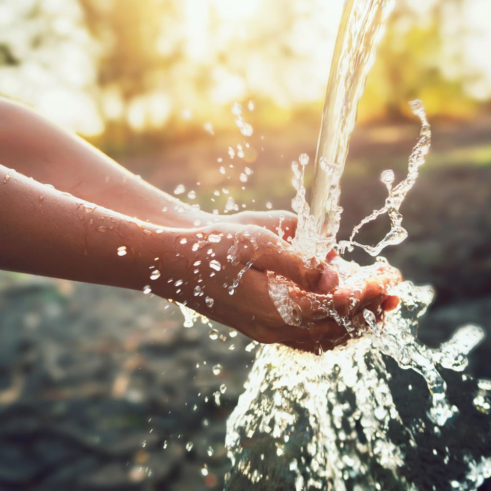 Hände unter einem Wasserstrahl