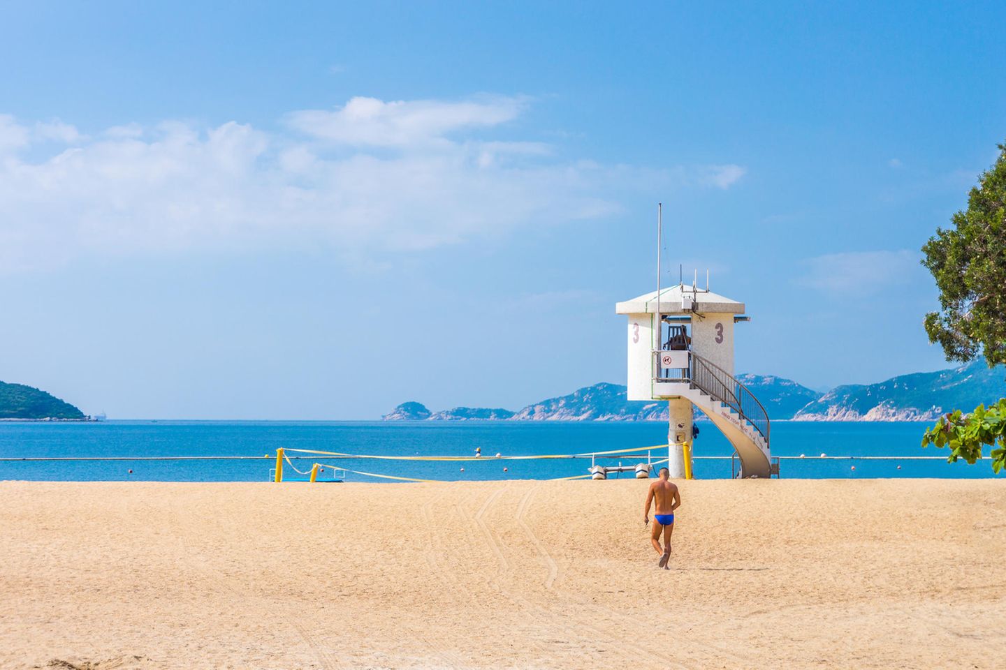 Schwimmer in blauer Badehose an der Repulse Bay, Hongkong