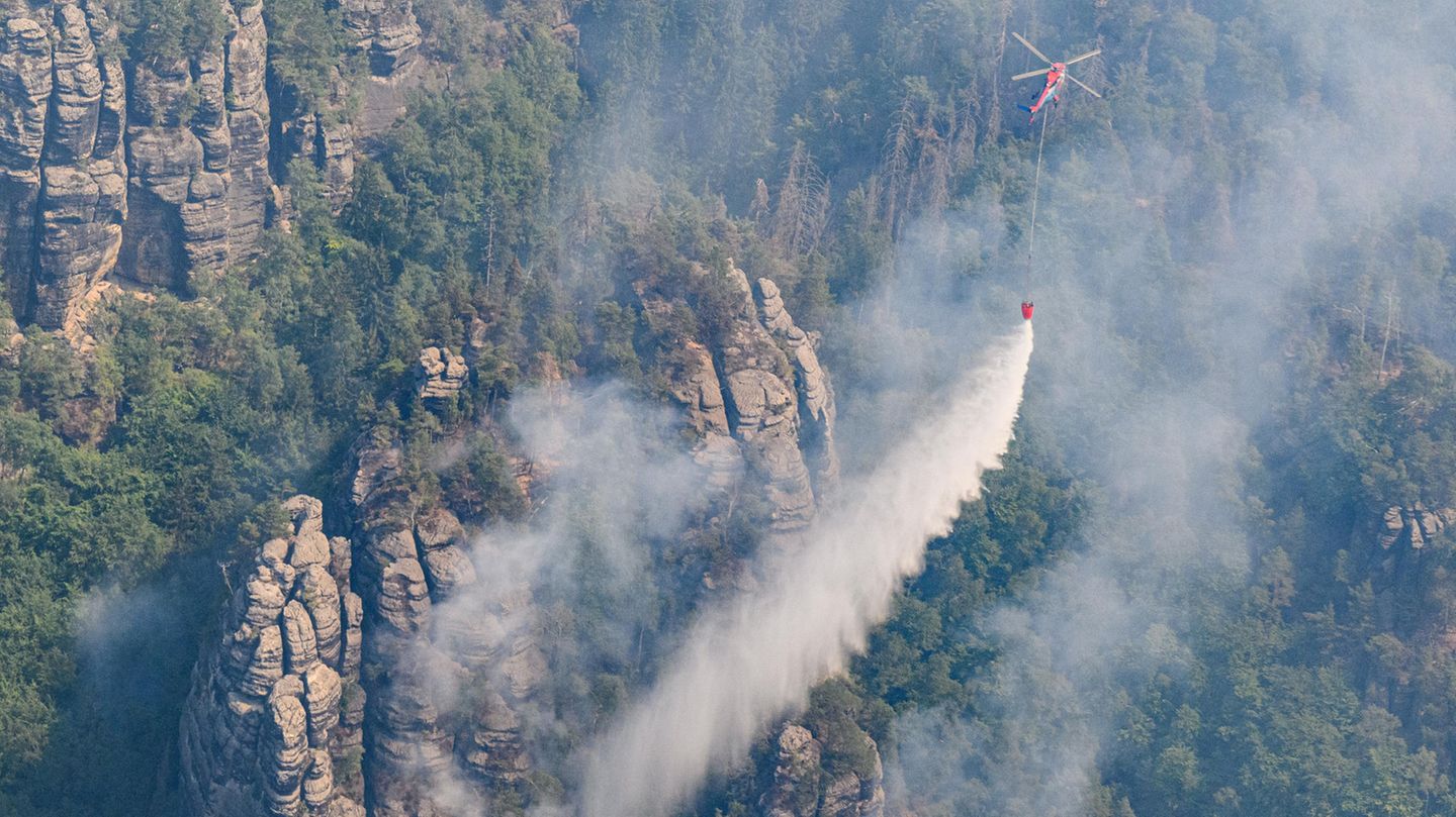 Die Bilder wirken verheerend, der Wald wird sich trotzdem erholen: Ein Lastenhubschrauber aus Österreich lässt Löschwasser auf Glutnester im Nationalpark Sächsische Schweiz fallen