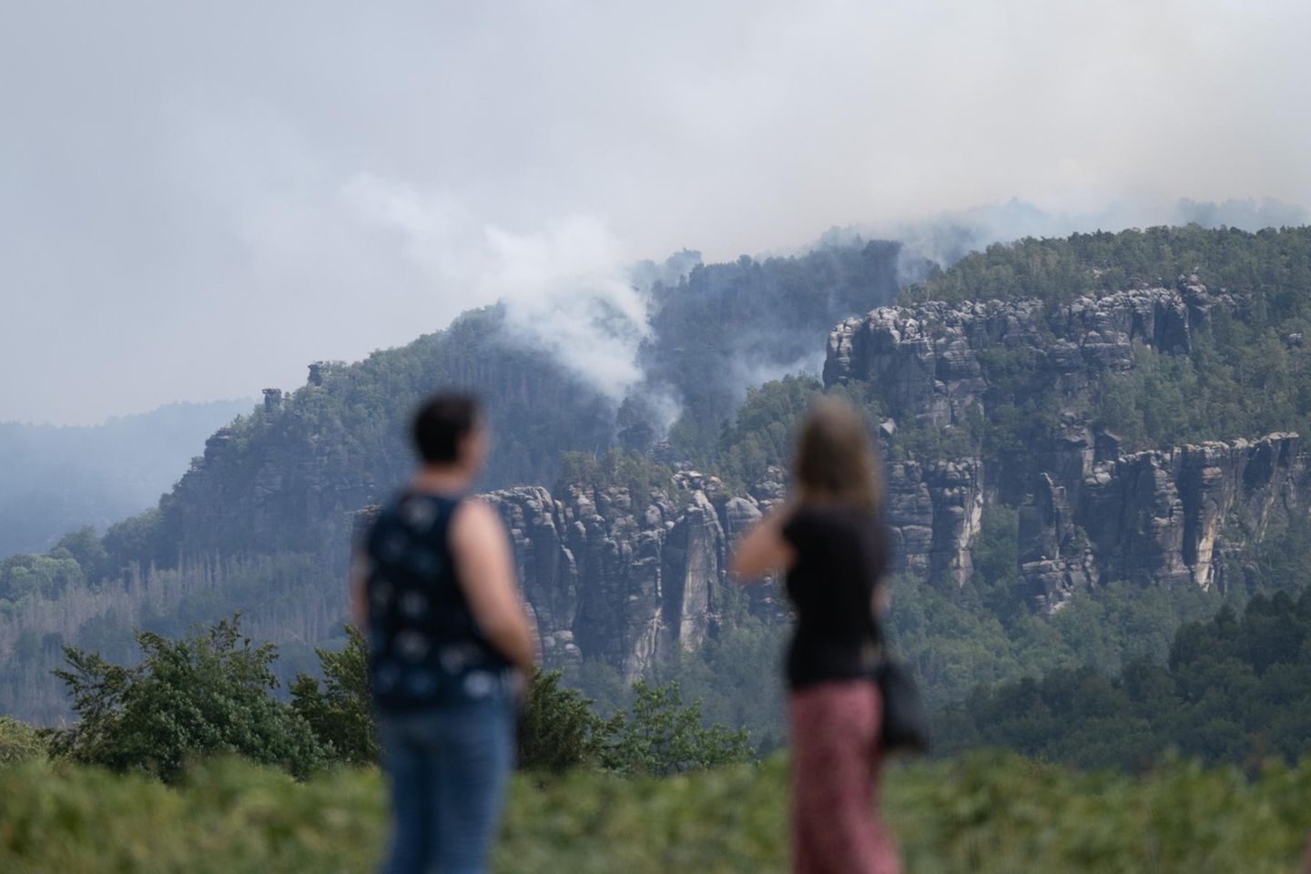 Was sonst das Wahrzeichen der Region ist, wird zum Hindernis. Die eindrucksvollen Sandsteinformationen, die aus den bewaldeten Hügeln der Region ragen, machen das Gelände für Löscharbeiten nur schwer zugänglich