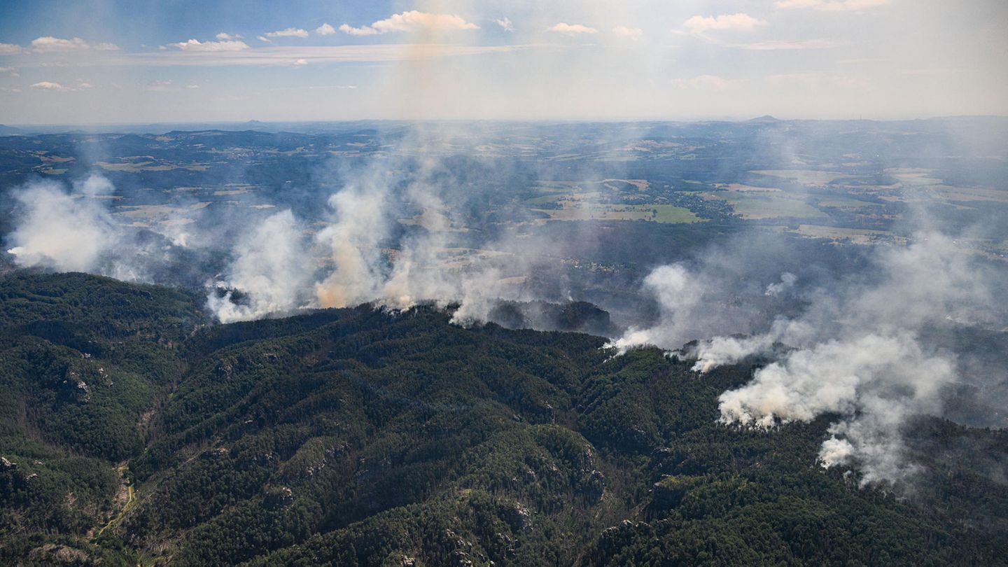 Der Blick aus einem Hubschrauber der Bundespolizei offenbart das Ausmaß der Brände. Zwar gelingt es den Feuerwehren am zwölften Tag, die Brandfläche auf 150 Hektar zu begrenzen, trotzdem ist es laut Nationalparkverwaltung der größte Flächenbrand seit 1842