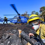 Sie werden von freiwilligen Feuerwehrleuten des Internationalen Katastrophenschutzes Deutschland unterstützt, die am Boden nach verbleibenden Glutnester suchen und diese löschen