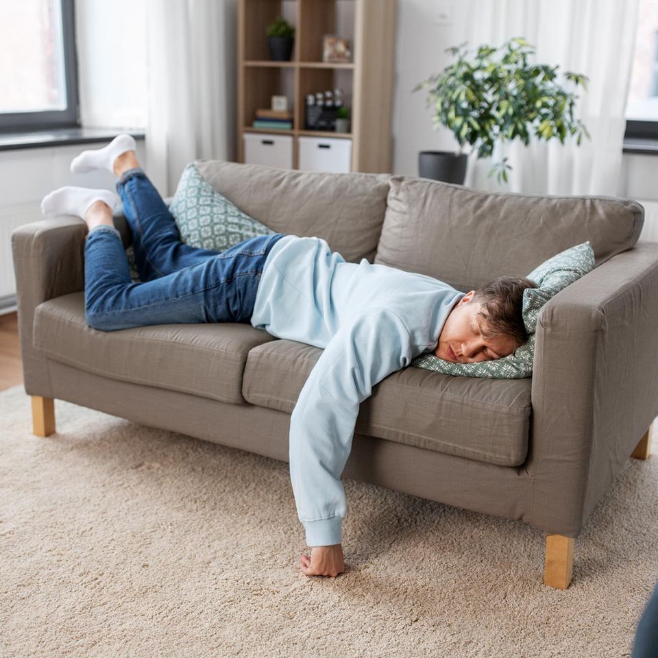 Mann schläft auf dem Sofa