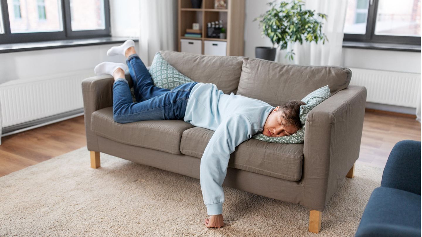 Mann schläft auf dem Sofa