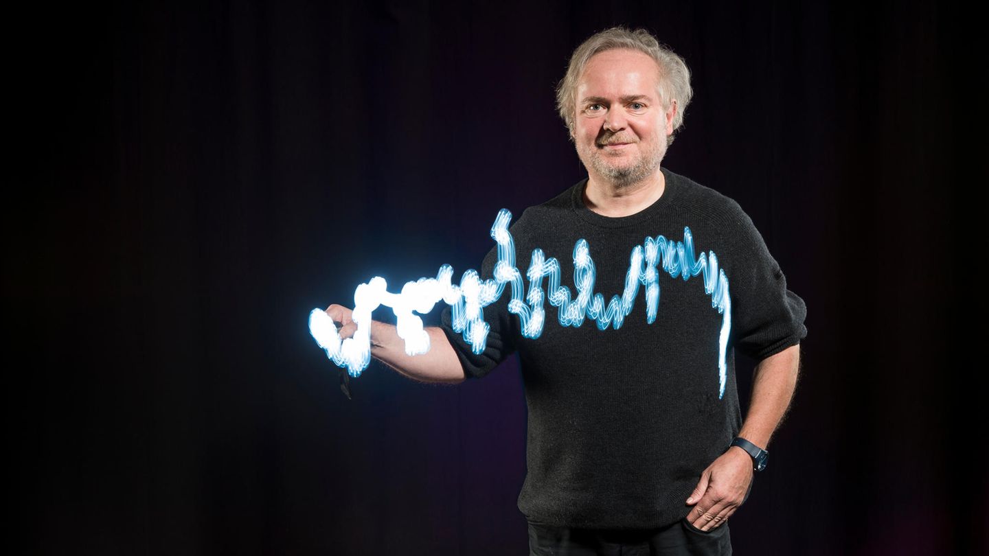 Wie stark Parkinson die Hand zittern lässt, demonstriert Broschart vor der Operation mithilfe einer Taschenlampe. Das Wort, das er skizziert, lautet "vorher" 