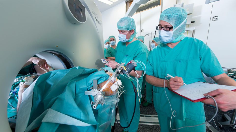 Teamarbeit am Universitätsklinikum Eppendorf: Neurophysiologe Christian Moll testet, Neurochirurg Wolfgang Hamel notiert den Stimulationseffekt; Neurologe Peter Ludewig prüft die Hand des Patienten 