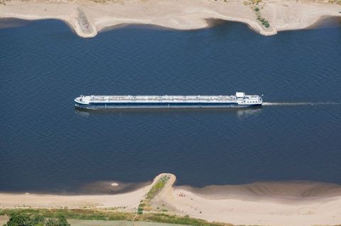 Ein Schiff mit wenig Ladung fährt bei Köln bei niedrigem Wasserstand auf dem Rhein