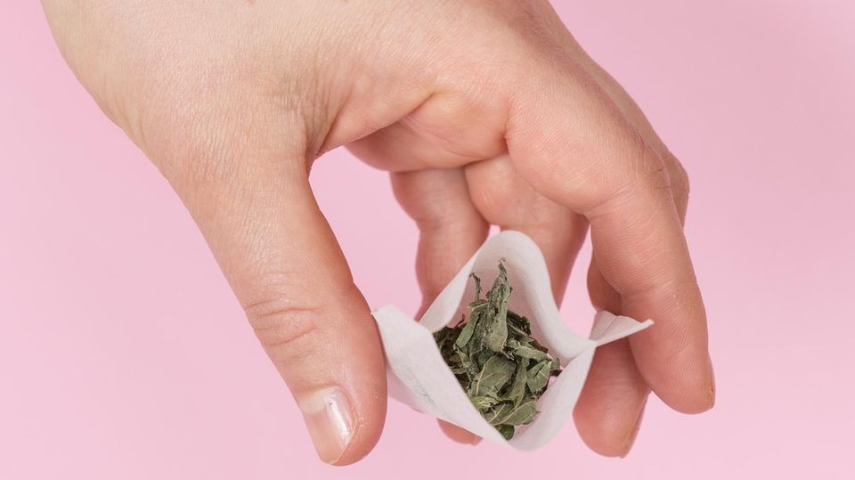 Der Teebeutel wird mit Kräutern gefüllt Der Teebeutel wird mit Kräutern gefüllt