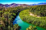 Türkisfarbener Fluss, der sich durch ein grünes Ufer schlängelt