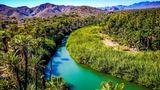 Türkisfarbener Fluss, der sich durch ein grünes Ufer schlängelt