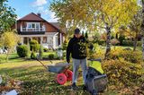 Gärtner zerkleinert Äste in einem Häcksler