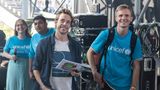 Tobias Krell alias "Cecker Tobi" (2. von rechts) steht mit Moderationskarten und einem Mikrofon hinter der Bühne.