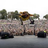 Der Künstler DONIKKL springt auf der Bühne hoch in die Luft, im Hintergrund sieht man ganz viele Menschen im Publikum.