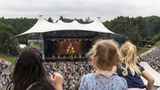 Menschen im Publikum schauen auf die Bühne, auf der Künstler und Künstlerinnen auftreten.