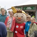 Kinder stehen für ein Foto zusammen mit einem Maskottchen der Deutschen Bahn.