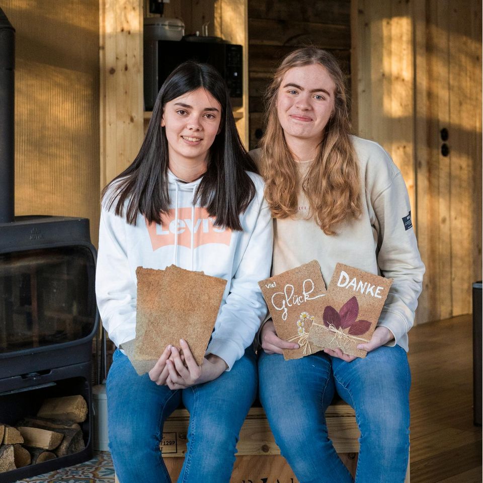 Die 15-jährigen Schulfreundinnen Emma (rechts) und Hanna (links) halten ihr selbst gemachtes Laub-Papier in den Händen.