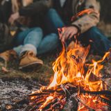 Ein Paar sitzt zusammen an einem Lagerfeuer