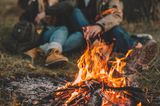 Ein Paar sitzt zusammen an einem Lagerfeuer