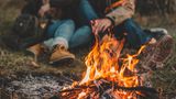 Ein Paar sitzt zusammen an einem Lagerfeuer