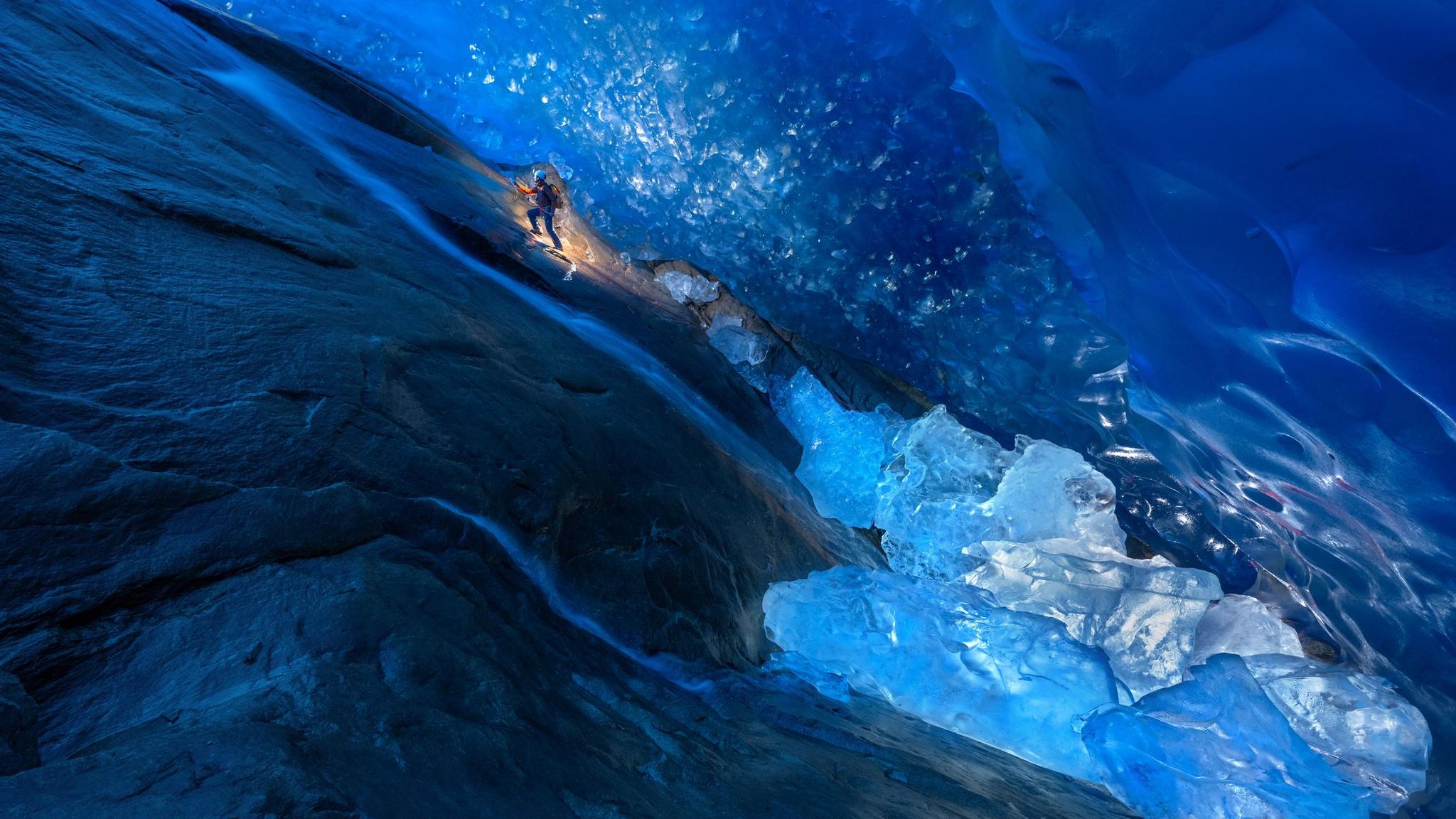 Am Seil gesichert steigt GEO-Reporter Lars Abromeit durch eine Höhle, die ein Fluss in den Aletschgletscher gegraben hat. Bis zu 800 Meter dick ist der Eispanzer im Schweizer Kanton Wallis