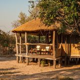 Eine Lodge mit zwei Stühlen in der Sonne