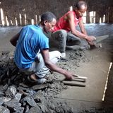 Der Zementboden wird geglättet. Später werden mehr als 100 Dorfbewohner mit anpacken, um die löchrigen Wände zu erneuern: mit einer Mischung aus Lehm und Stroh.