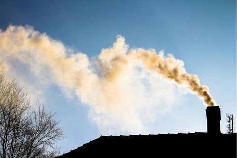 Rauch steigt aus dem Schornstein eines Einfamilienhauses