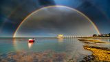 Photographer name: Jamie Russell      From: Shanklin, Isle of Wight, UK      Age: 44      Photo title: Departing Storm Over Bembridge Lifeboat Station     Photo location: Bembridge, Isle of Wight, UK     Date photo taken: May 27 2022      Caption: After chasing storms and showers west to east across the Isle of Wight to capture some incredible rainbows, Jamie reached Bembridge as the final shower left. "In a panic (he) waded into the waist-deep water, fully dressed, just to compose this scene".      Rainbows are optical phenomena that occur when sunlight shines through raindrops. The light is refracted as it enters the raindrop, then reflected off the back of the droplet and then refracted again as it exits and travels towards our eyes. This causes the sunlight to split into different colours. The sun needs to be behind the viewer and needs to be low in the sky. The lower the sun in the sky, the more of an arc of a rainbow the viewer will see. Also, the rain, fog, or other source of water droplets, must be in front of the viewer. The angle at which the light is scattered is different for everyone, which means that every rainbow is unique to the observer.      Double rainbows form when sunlight is reflected twice within a raindrop. They are relatively common, especially when the sun is low in the sky, such as in the early morning and late afternoon. The second rainbow is fainter, and more 'pastel' in tone and a key feature of a double rainbow is that the colour sequence in the second rainbow is reversed.      Story behind the photo: I had been chasing showers and storms from west to east across the island in an attempt to capture some of the incredible rainbows. I reached Bembridge as the final shower departed and in a panic waded in to waist deep water, fully dressed just to compose this scene!      Media interviews:      Social media:          https://www.facebook.com/Island.visions.photography/  https://www.instagram.com/island_visions_photography/      Camera: Nikon d7500, Sigma 10-20 lens. Exposure time 1/200, f10, ISO 400