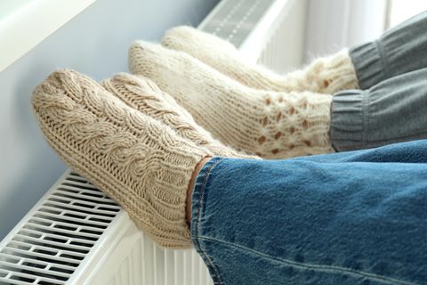 Füße in Wollsocken auf einer Heizung