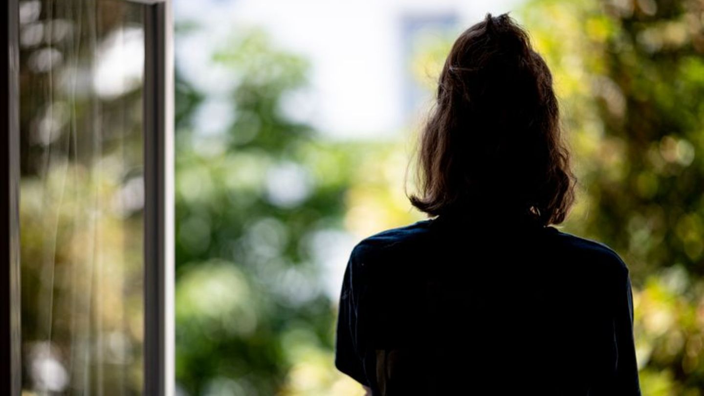 Frau am offenen Fenster