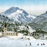 Für bestimmte wohlhabende Kreise aus der elitären Gesellschaft ist das Alpenparadies nicht nur eine unberührte Natur, sondern auch ein eleganter Rückzugsort auf Zeit, in dem man wie im Winter an der Côte d’Azur unter sich bleibt. Dieses Photochrom, das Männer mit Zylindern auf Schlitten beim Hinabrutschen an einem verschneiten Hang vor einer katholischen Kirche in den Alpen zeigt, verbildlicht es nur zu gut.