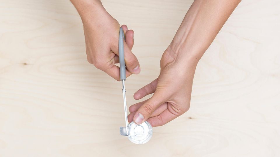 Winter-Basteln: Von einem Teelicht wird mit einer Schere ein kleines Plättchen abgeschnitten. Winter-Basteln: Von einem Teelicht wird mit einer Schere ein kleines Plättchen abgeschnitten.