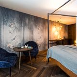 Hotelzimmer mit blauen Sesseln und Holzfußboden