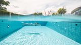 Unterwasseraufnahme von einer Frau, die im Pool schwimmt