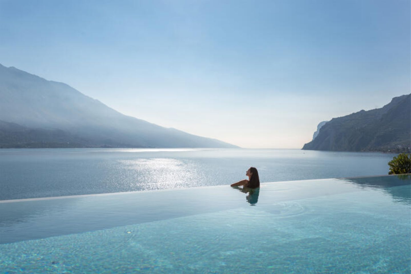 Kategorie Neu: Eala am Gardasee, Italien Eine Frau in einem Infinitypool, hinter dem der Gardasee liegt
