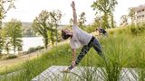 Zwei Frauen machen Yoga auf einer Wiese