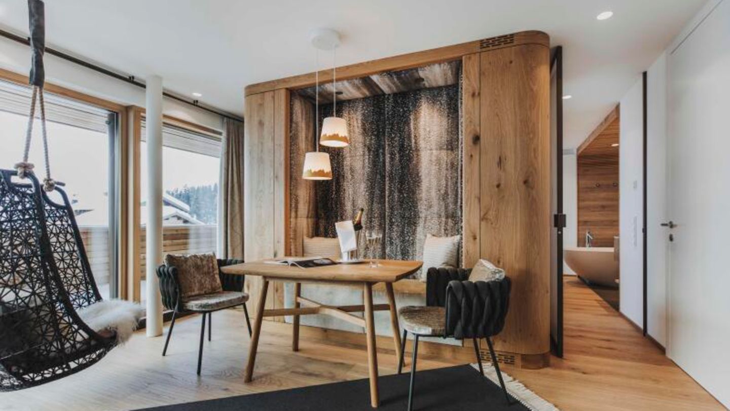 Kategorie Nachhaltig: Goldener Berg am Arlberg, Österreich Ein Holztisch mit zwei Stühlen in einem Hotelzimmer