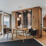 Ein Holztisch mit zwei Stühlen in einem Hotelzimmer