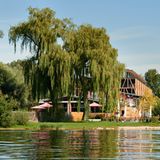Großes Hotel am See mit einem Baum davor