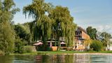 Großes Hotel am See mit einem Baum davor