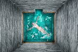 Eine Frau schwimmt an der Wasseroberfläche in einer Therme