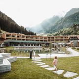 Kleine Kinder laufen vor dem Hotel entlang, das zwischen den Bergen liegt