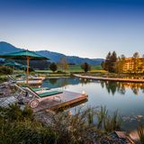 Großer beleuchteter Außenpool mit dem Hotel im Hintergrund