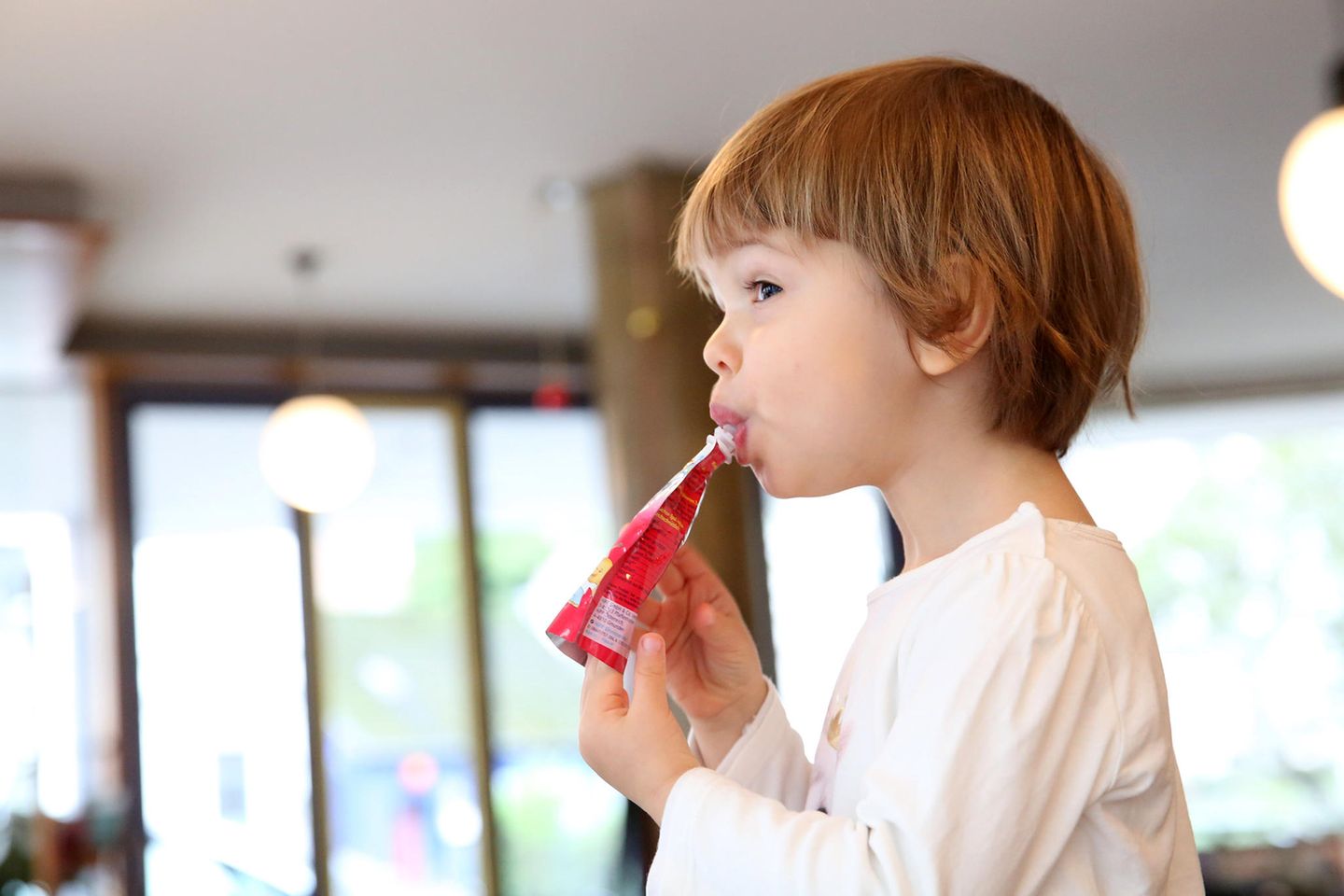 Obstbrei in Tüten: viel Zucker, wenig Vitamine Ein zweijähriges Maedchen nuckelt an einem Quetschie