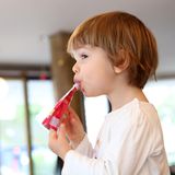 Ein zweijähriges Maedchen nuckelt an einem Quetschie